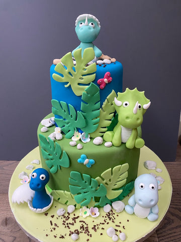 Cute 2 tier birthday cake with baby dinosaurs to decorate