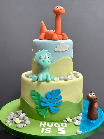2 tiered birthday cake with dinosaurs to decorate
