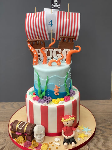 2 tier birthday cake with ship, stripes, octopus, pirate and treasure chest