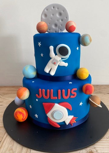 Space-themed birthday cake with astronaut, planets, and moon
