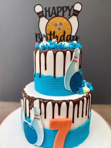 2 tier drip cake with bowling decorations