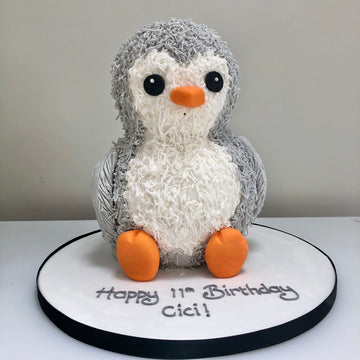 Cake carved and decorated to look like a penguin