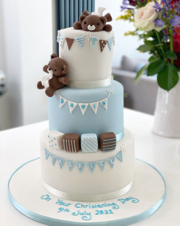 3 tiered christening cake decorated with partying teddies, bunting and blocks