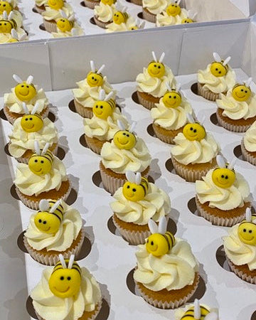 Cupcakes decorated with yellow bees and smiley bee faces