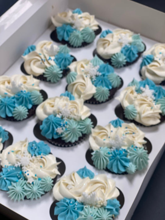 Assorted cupcakes with blue and white frosting on a tray.