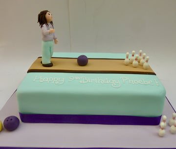 Bowling-themed birthday cake with a figure, ball, and pins o
