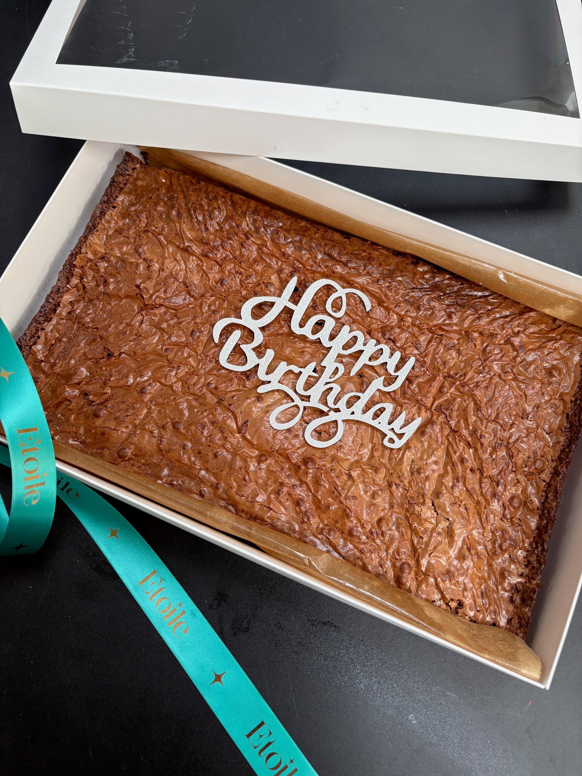 Brownies in a box with 'Happy Birthday' text on a black background