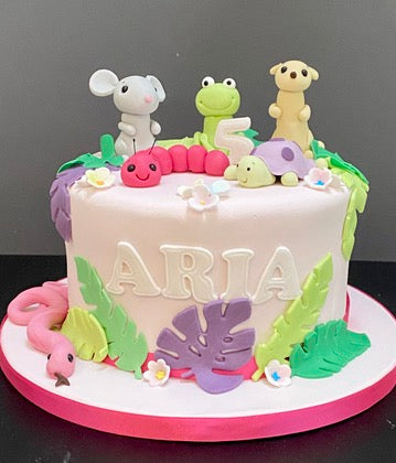 birthday cake with animals and colourful sugar bugs to decorate