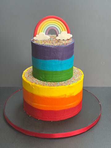 Rainbow buttercream cake with a sugar rainbow on top