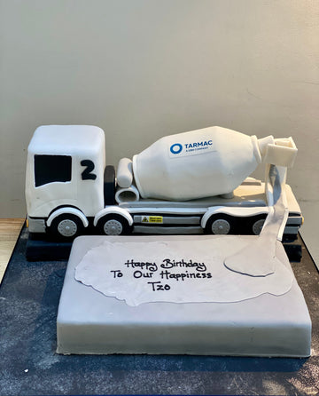 Birthday cake with a cement truck decoration featuring the Tarmac logo.