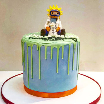 Blue and green drip birthday cake in chemistry theme with a mad scientist on top of the cake