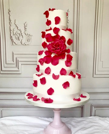 four tier White wedding cake with red flowers and petals