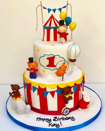 Circus-themed 2 tier birthday cake with teddy bears and balloons on a white background