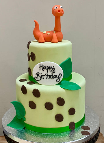 2 Tier Cake with dinosaur footprints and a dinosaur on top