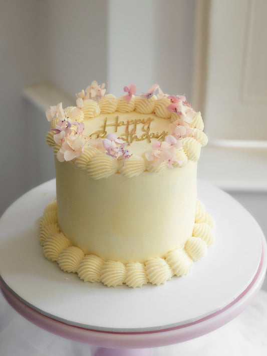 piped buttercream cake with dried hydrangeas on top to decorate