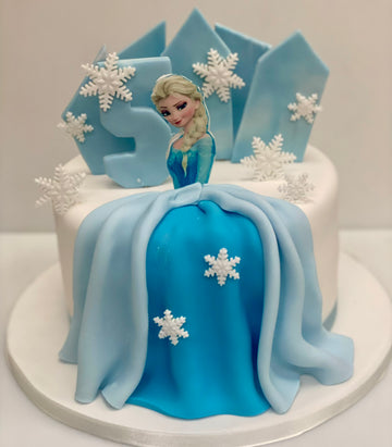 Elsa birthday cake with an incing dress, snowflakes and ice shards