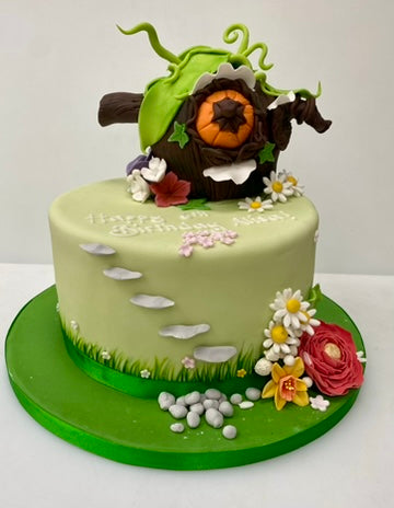 Cake decorated with a cute fairy house and sugar flowers
