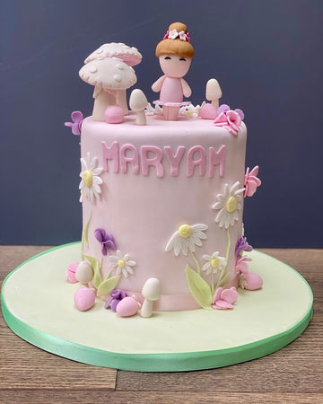 Cake decorated with fairies and daisies and toadstools