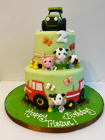 2 tiered farmyard themed birthday cake with tractors and farm animals