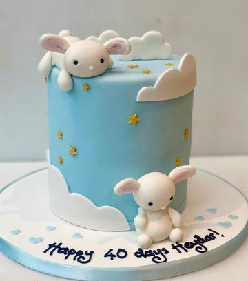 Birthday or babyshower cake decorated with clouds and sleepy bunnies
