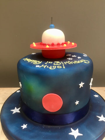 Space-themed birthday cake with UFO sugar figure on top