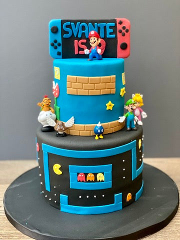 Video game-themed birthday cake with Mario characters, Pacman and a gaming controller
