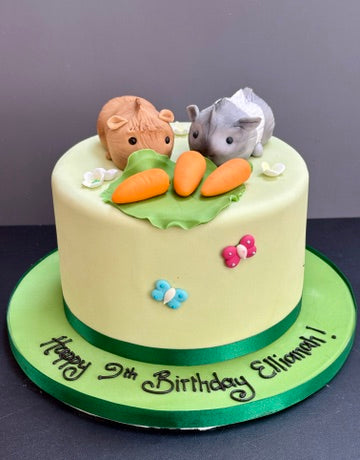 birthday cake with icing guinea pigs on top