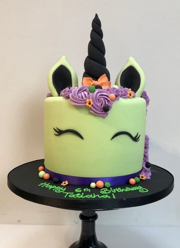 Unicorn Cake in a Halloween Style with green, purple, orange and black decorations