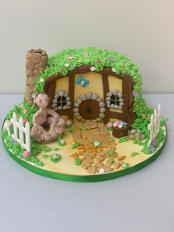 Birthday Cake Decorated to look like a hobbit house with gollum as a sugar figure from lord of the rings