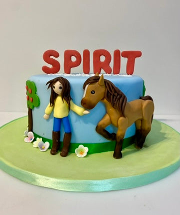 Birthday cake decorated with a sugar horse and a girl