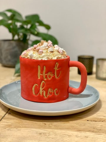 Cake decorated to look like a red mug of hot chocolate