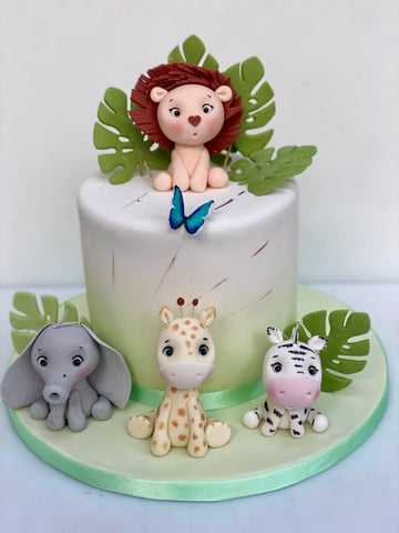 Ombre jungle themed tall birthday cake decorated wtih sugar lion, elephant, giraffe and zebra