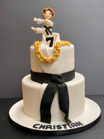 Two-tiered cake with a karate-themed topper