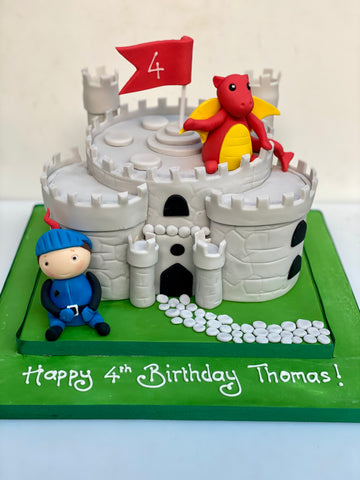 Castle shaped birthday cake with a knight and dragon