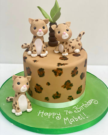 Children's birthday cake decorated with sugar leopards and a leopard print