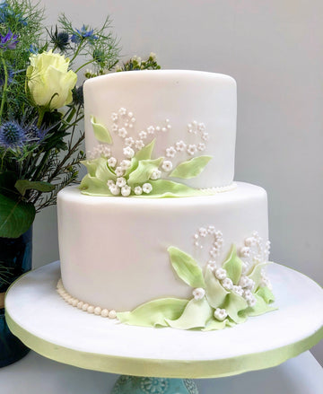 2 tiered cake with sugar lily of the valley flowers to decorate