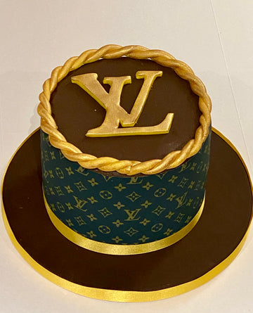 Cake designed to resemble a Louis Vuitton box with gold accents on a white background