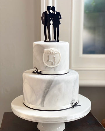 2 tiered marble effect wedding cake with a gay cake topper of two men