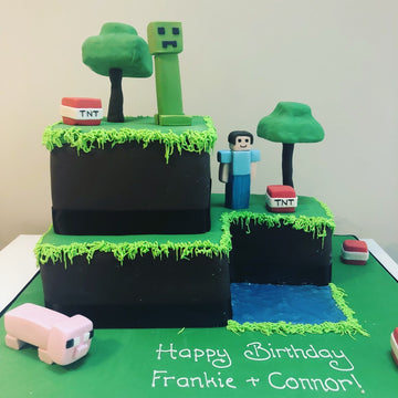 Two tier birthday cake in the Minecraft theme with minecraft pigs, creepers TNT and Dave