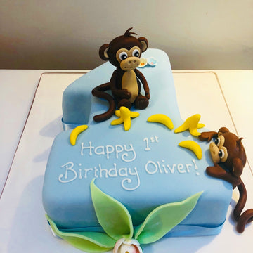 CAke in the shape of a number 1 with monkey and bananas to decorate