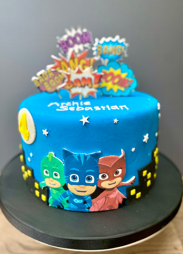 Blue cake with PJ Masks characters and colorful toppers