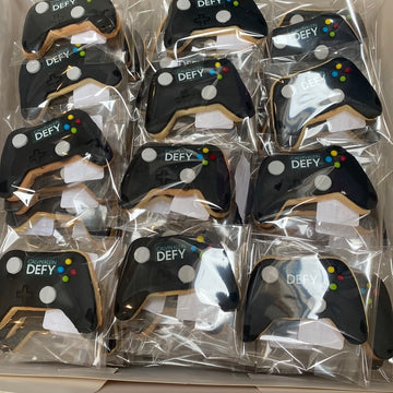 Packaged cookies shaped like game controllers with Calvin Klein 'DEFY' branding.