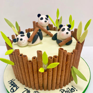 Cake decorated with biscuit bamboo and panda figurines on top