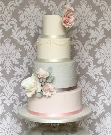 4 tiered Pastel pink and grey and white 4 tier wedding cake with sugar roses and piping and a lattice stencil