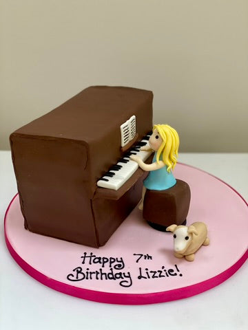 Birthday cake with a piano and a girl playing it