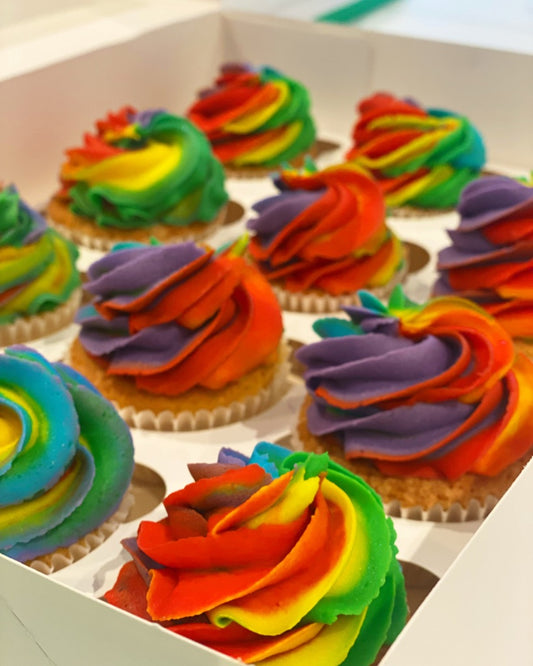 Colorful rainbow cupcakes in a box