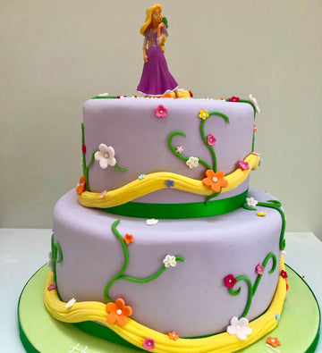 2 tiered cake wtih rapunzel and her hair wrapped around the cake