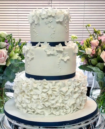 Ruffle and Tumbling Hydrangea Three Tier Wedding Cake with ruffle bottom tier and the top two tiers with sugar hydrangea blossoms tumbling down