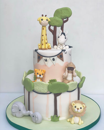 2 Tiered Birthday cake decorated in safari style with jungle animals and a safari person