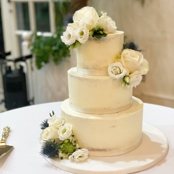 3 tier semi naked wedding cake decorated with roses and flowers and thistles delivered to kew gardens